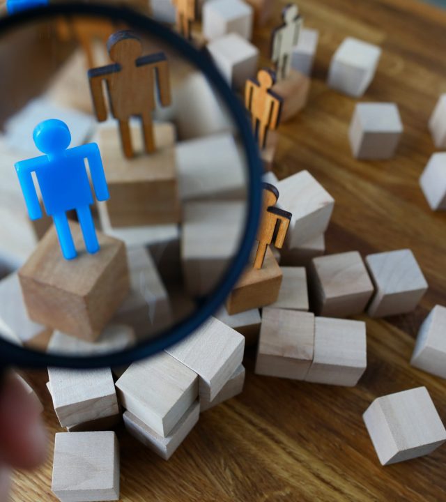 Businessman hold in hand magnifying glass. Look at silhouette of blue toy man. Lgbtq people search career concept.